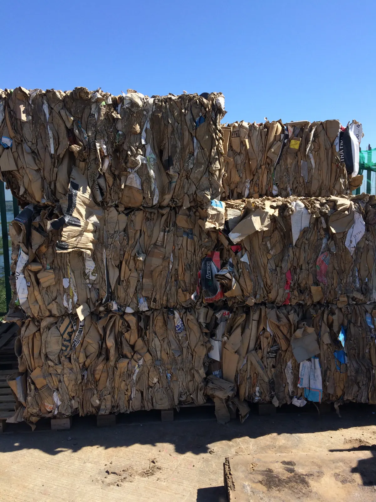 How much is a cardboard bale worth — stacked cardboard bales outdoors awaiting sale and collection